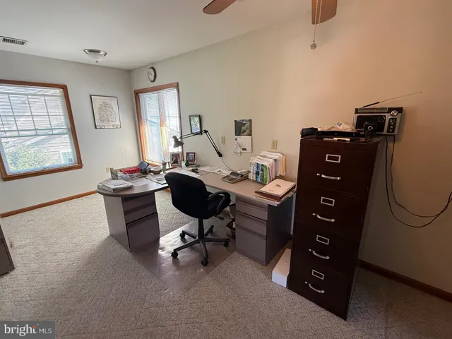 a view of a workspace with furniture and a window