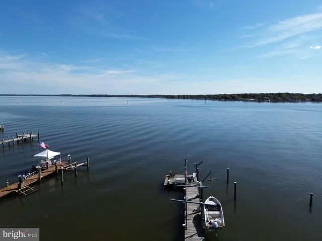 a view of a lake with a bench in the patio and garden