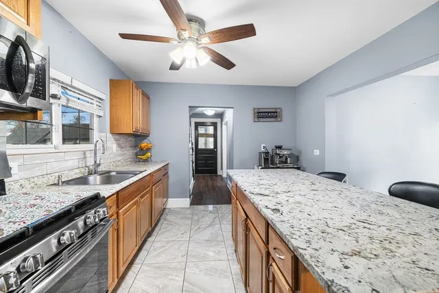a large kitchen with kitchen island granite countertop a sink stove and refrigerator