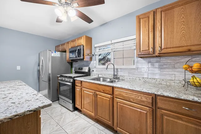 a kitchen with stainless steel appliances granite countertop a sink stove and refrigerator