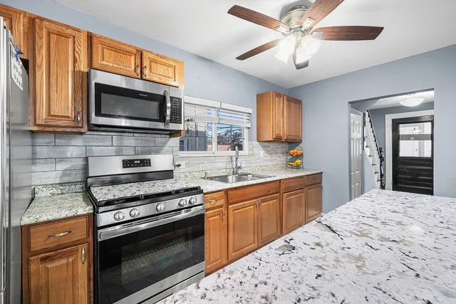 a kitchen with stainless steel appliances granite countertop a stove microwave and refrigerator