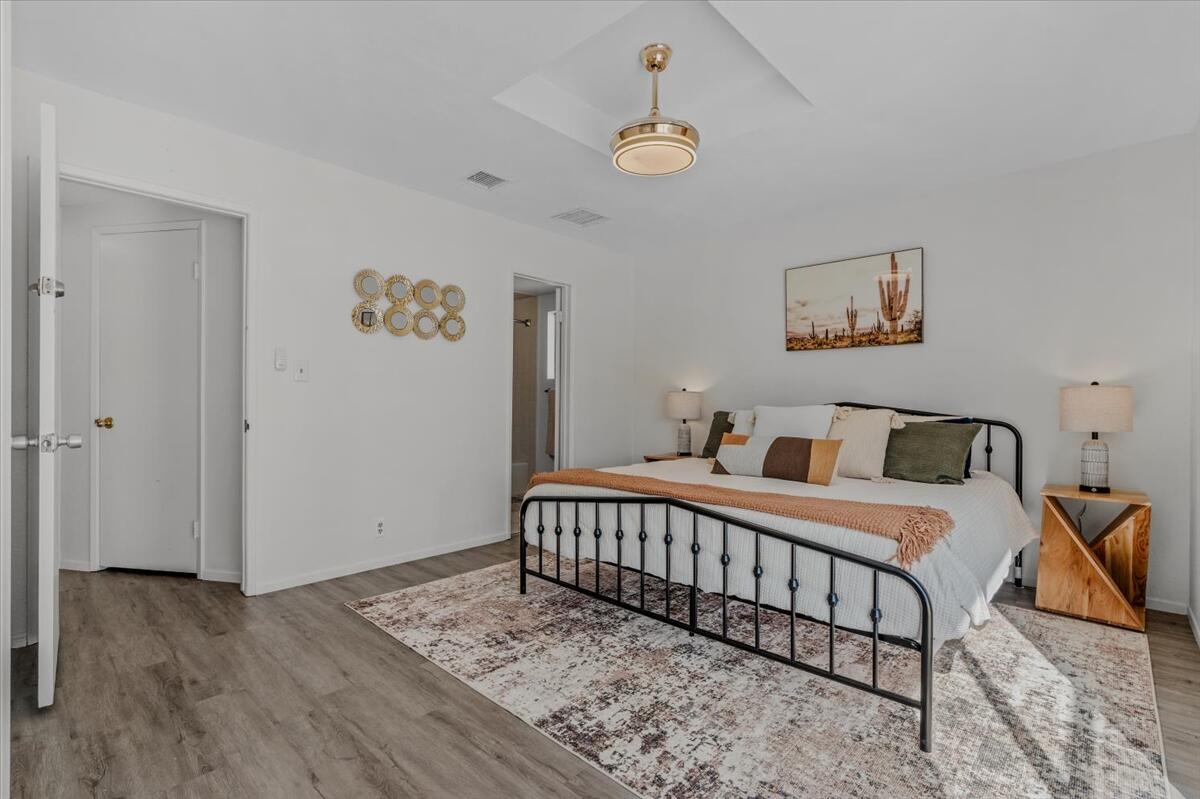 63555 Walpi Drive Joshua Tree, CA 92252 - Photo 14 of 30 a large bedroom with a bed and wooden floor