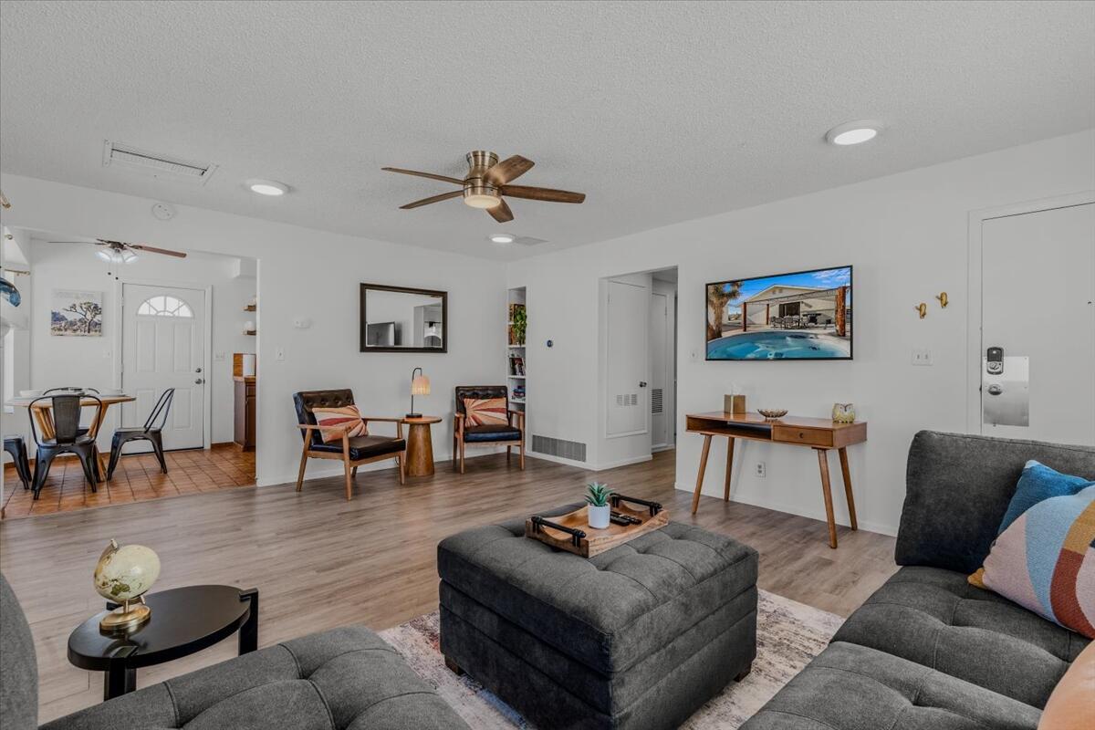 63555 Walpi Drive Joshua Tree, CA 92252 - Photo 6 of 30 a living room with furniture a rug and a chandelier