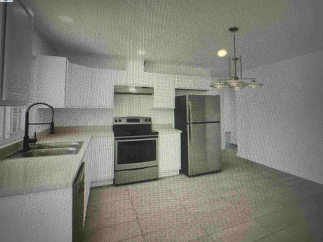 a kitchen with a sink a refrigerator and cabinets