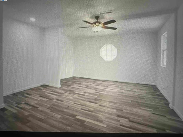 a view of a room with wooden floor and fan