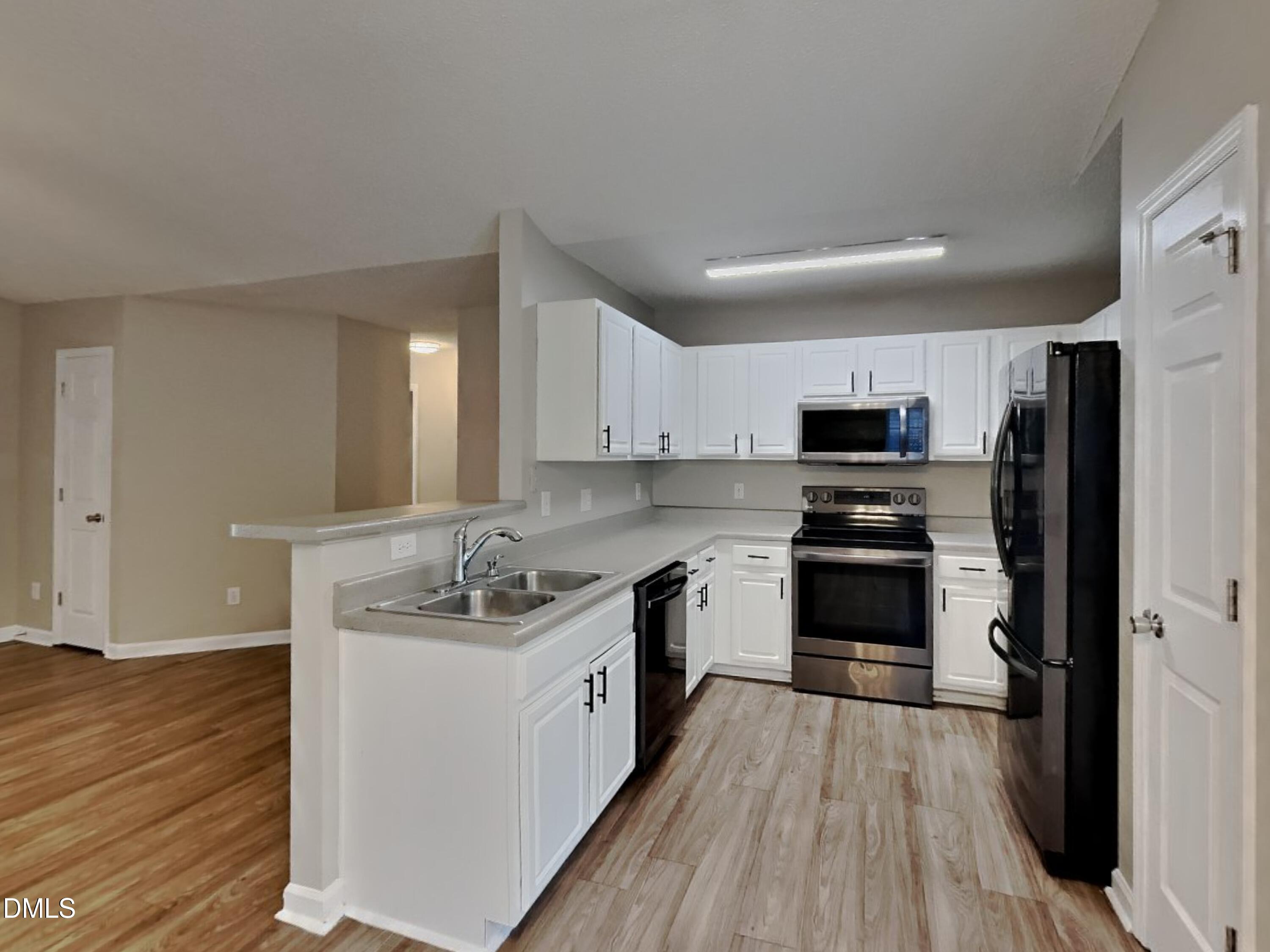 5516 Wilhagan Court Raleigh, NC 27616 - Photo 5 of 16 a kitchen with kitchen island granite countertop a sink cabinets and stainless steel appliances