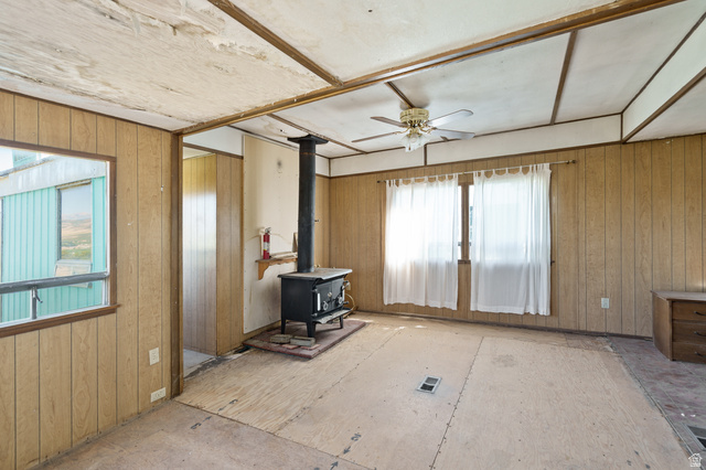 12615 Cedar Ridge Drive, Unit C41 Fairview, UT 84629 - Photo 16 of 32 Living area with wood walls, a wood stove, and a ceiling fan