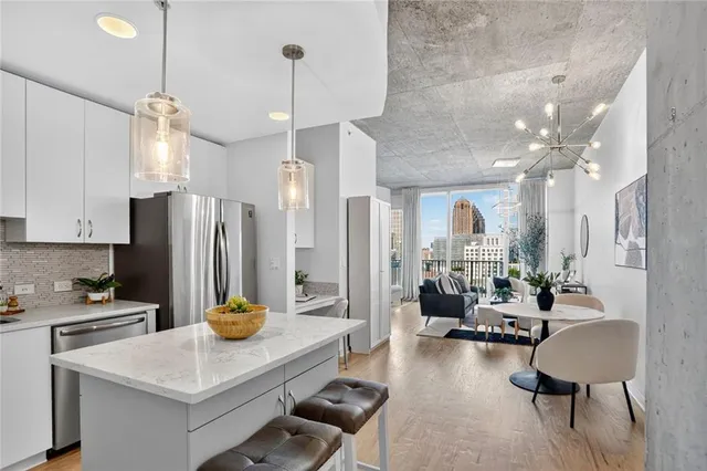 a kitchen with refrigerator and chairs