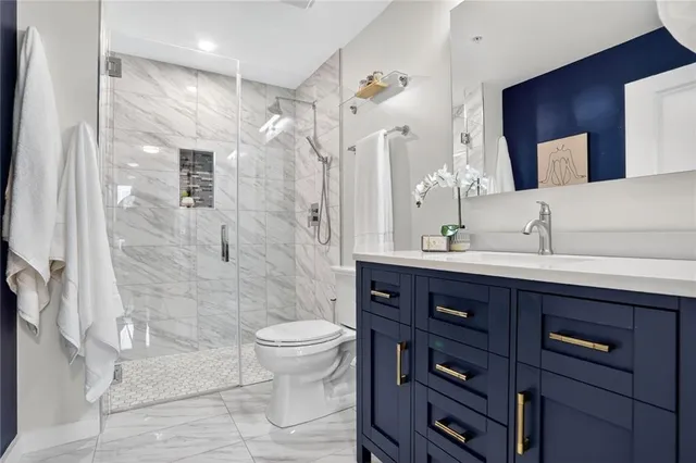 a bathroom with a sink a toilet and shower