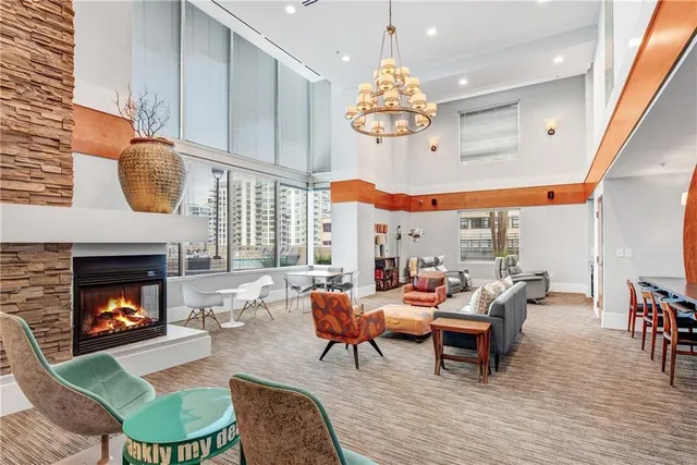 a living room with furniture a chandelier and a fireplace