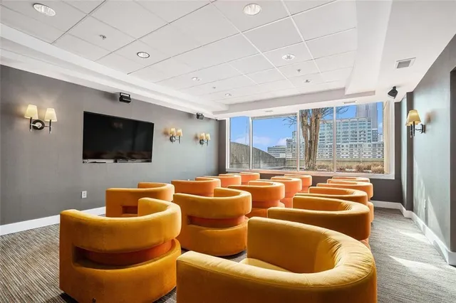 a projector room with furniture and a flat screen tv