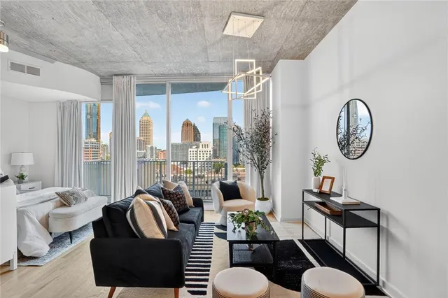 a living room with furniture a rug a fireplace and a large window