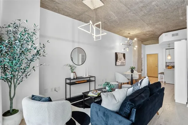 a living room with furniture a clock and a potted plant