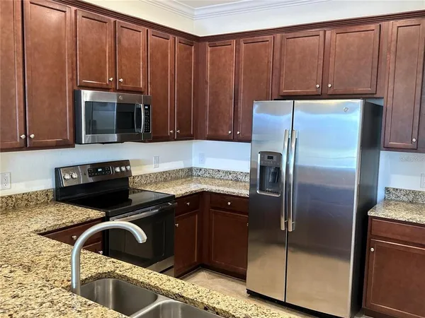 a kitchen with a refrigerator sink and cabinets
