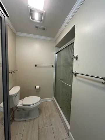 a bathroom with a toilet and a shower