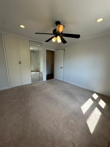 a view of an empty room and chandelier fan