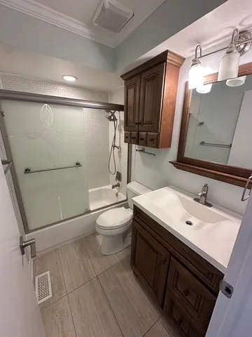a bathroom with a sink a toilet a mirror and shower