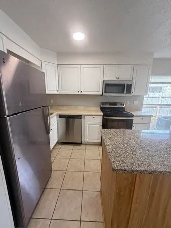 a kitchen with granite countertop a refrigerator and a sink