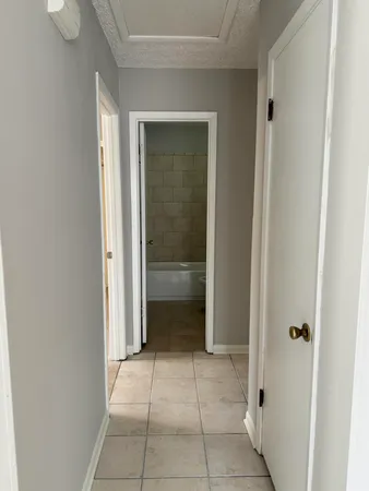 a view of an empty room with closet and mirror