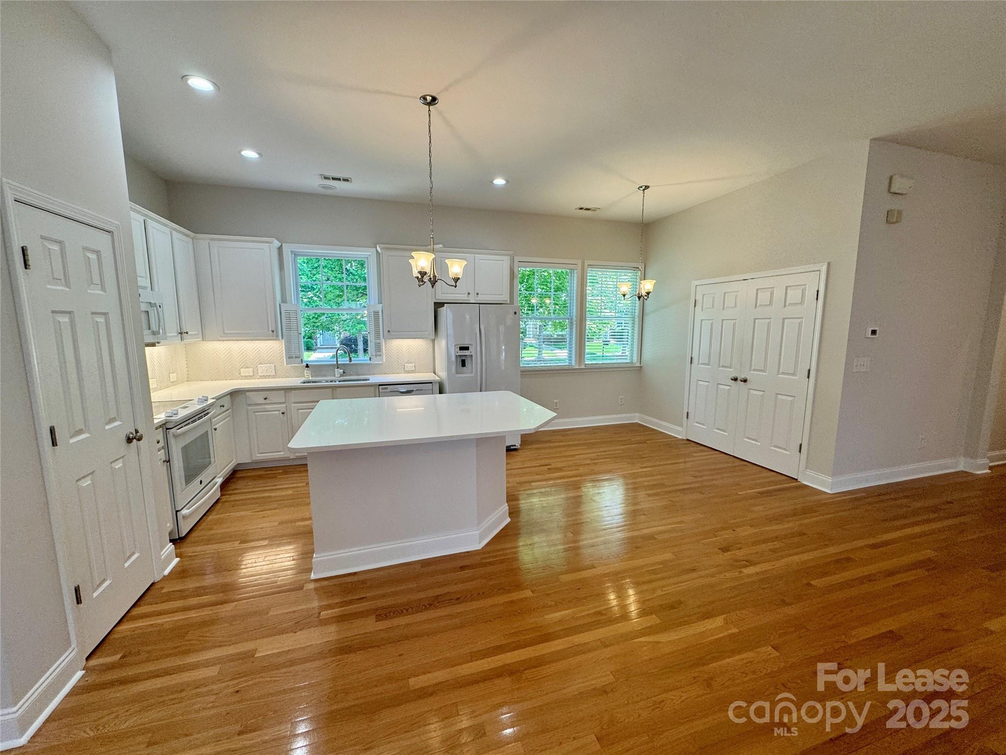 5340 Soaring Eagle Lane Mint Hill, NC 28227 - Photo 12 of 28 a large white kitchen with wooden floors