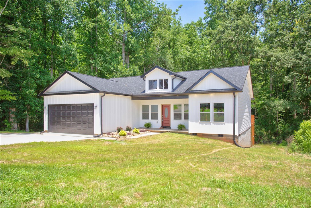 223 Maple Drive Anderson, SC 29621 - Photo 42 of 45 A modern farmhouse-style home with a dark roof and contrasting white siding awaits amidst verdant trees.