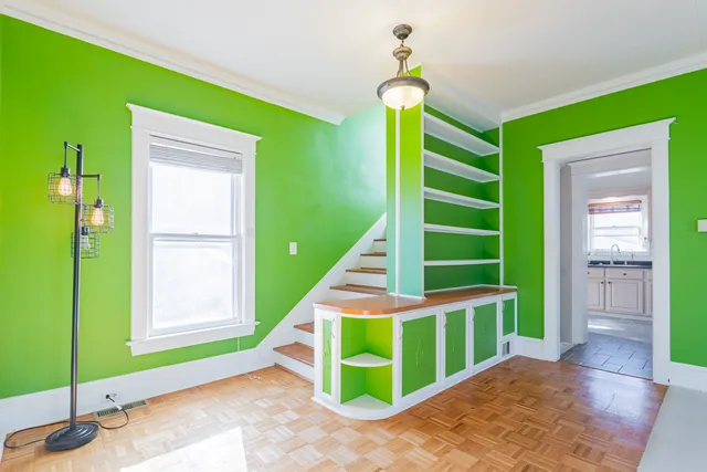 an empty room with wooden floor chandelier fan and windows