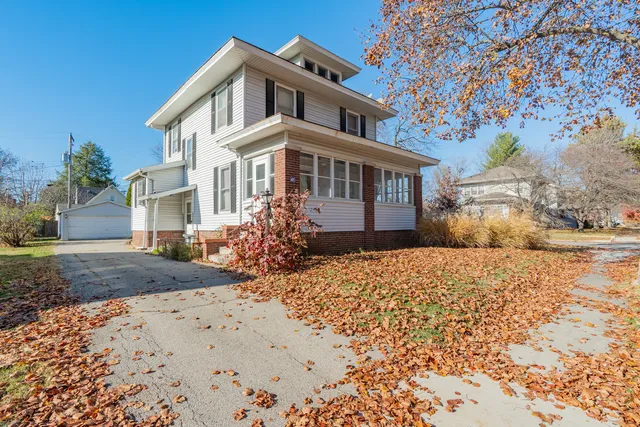 a front view of a house with a yard and shrubs
