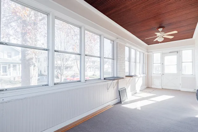 a view of an empty room with window and a kitchen