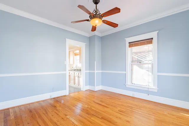 a view of empty room with window and ceiling fan