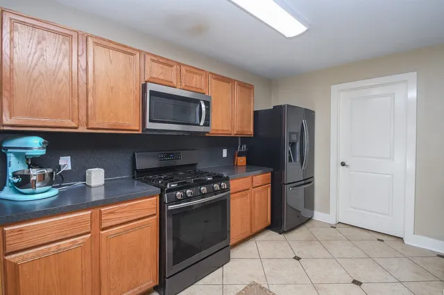 a kitchen with stainless steel appliances granite countertop a stove a refrigerator and a sink