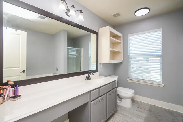 a bathroom with a sink a toilet and a mirror