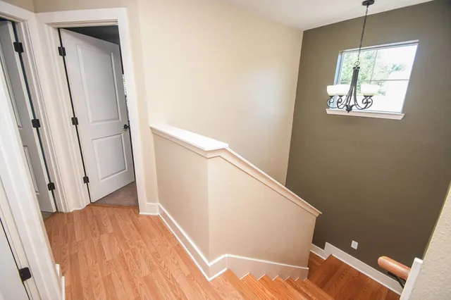 a view of a hallway with wooden floor and staircase