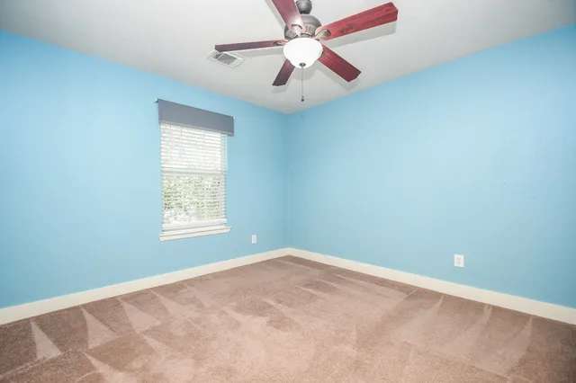 an empty room with a window and a fan
