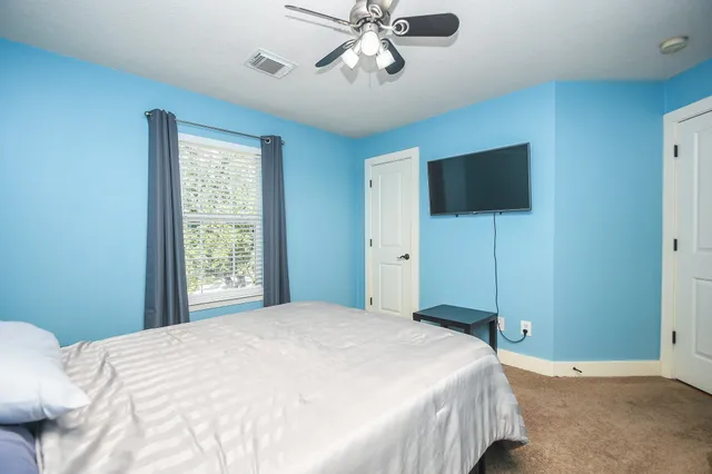 a bedroom with a large bed and a flat screen tv