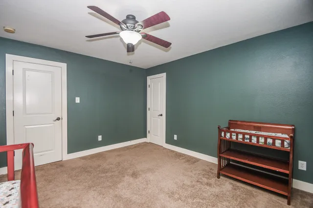 a view of room with stairs and a ceiling fan