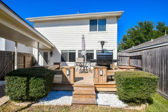 a front view of a house with fountain and potted plants