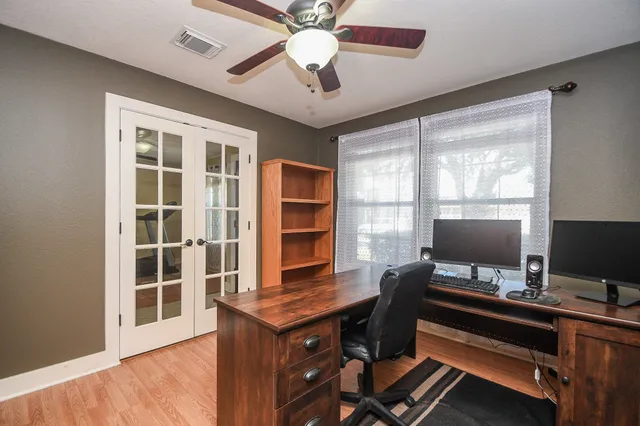 a view of a workspace with furniture and a window