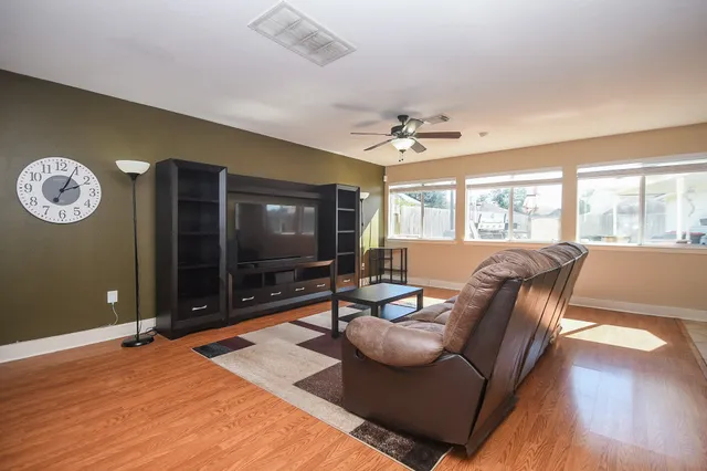 a living room with furniture a large window and a flat screen tv