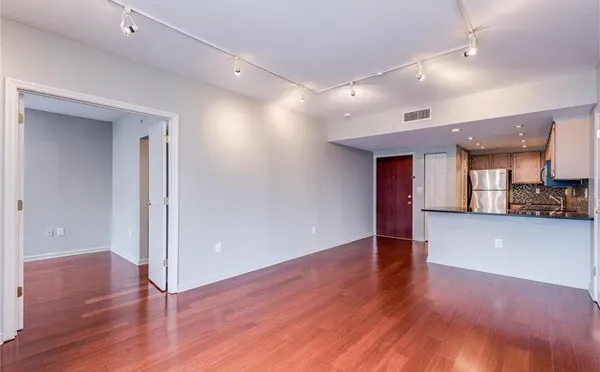 an empty room with wooden floor and a bathroom