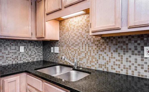 a kitchen with stainless steel appliances granite countertop a refrigerator a stove a sink and a microwave
