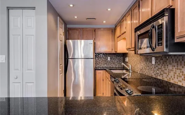 a kitchen with granite countertop a sink and a stove