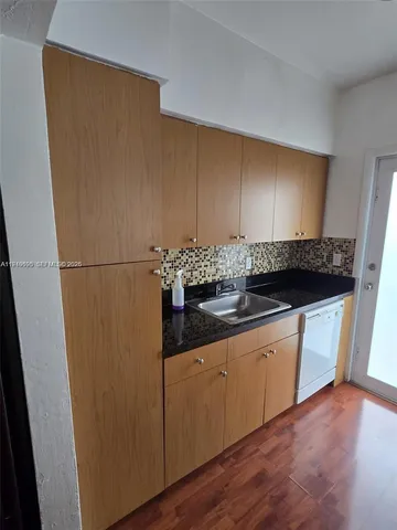 a kitchen with granite countertop a sink and cabinets