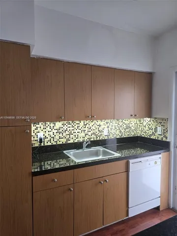 a kitchen with granite countertop cabinets and white appliances
