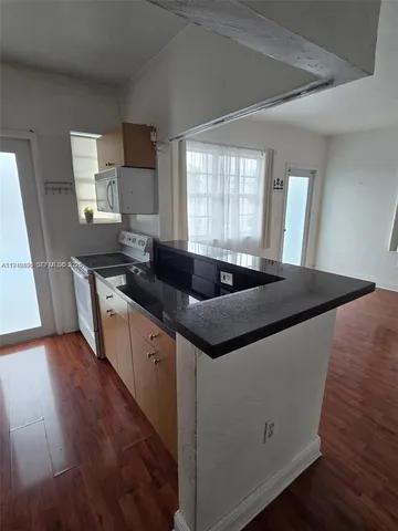 a kitchen with granite countertop a sink and a stove top oven
