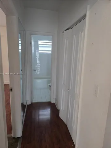 a view of a hallway with wooden floor