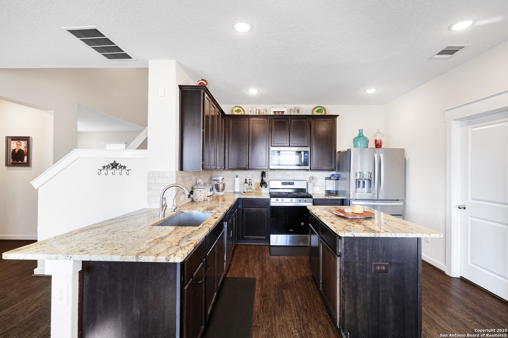 10614 Rosalina Loop Converse, TX 78109 - Photo 12 of 31 a kitchen with kitchen island granite countertop a sink stove and wooden cabinets