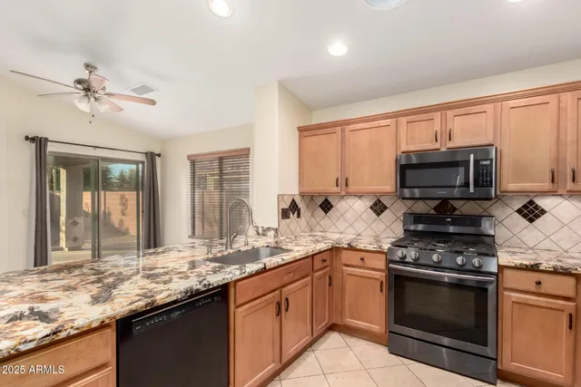 a kitchen with granite countertop a stove sink and microwave