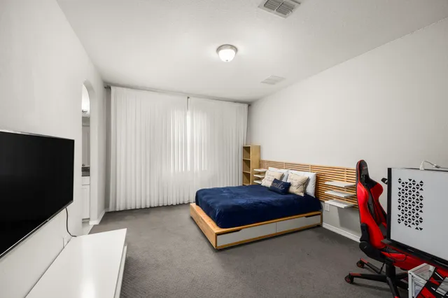 a bedroom with a bed and a flat screen tv