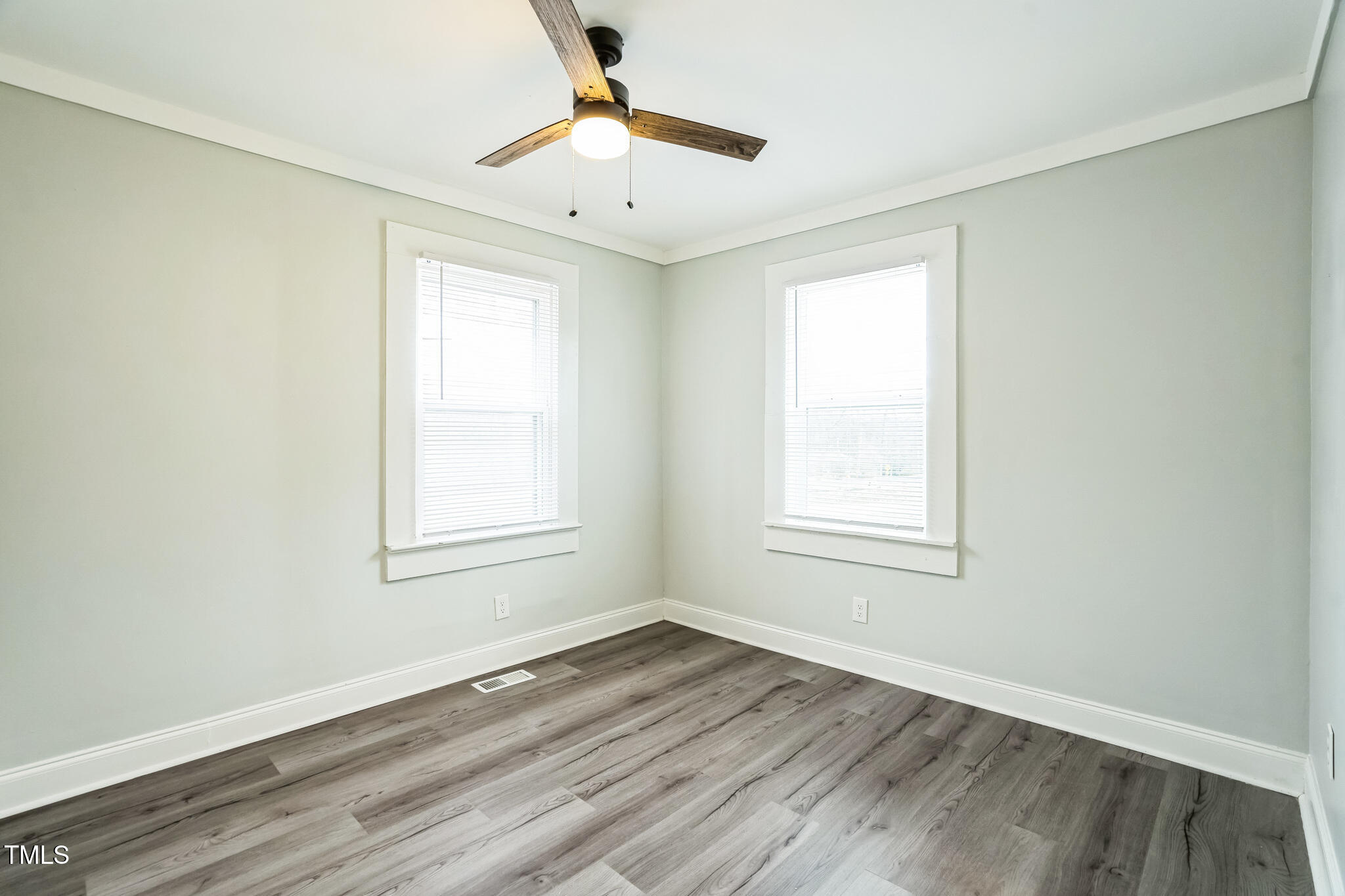 2400 Dorety Place Raleigh, NC 27604 - Photo 24 of 29 an empty room with wooden floor chandelier fan and windows