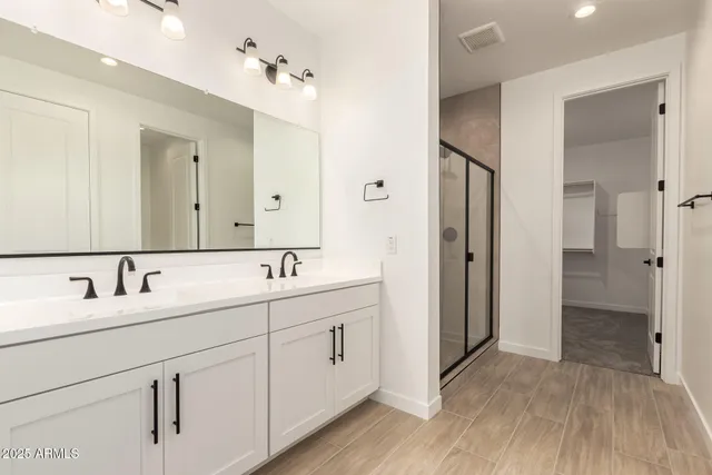 a bathroom with a double vanity sink and mirror